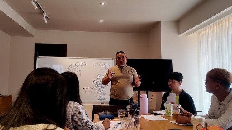 Facilitator Mr. Som Chanmony leads the discussion in front of a whiteboard