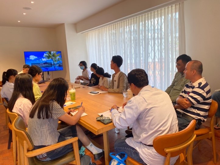 Participants gathered around a table for a group discussion at the Peace Café session